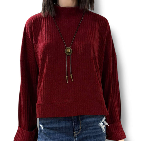 woman wearing a burgundy mock neck rib knitted sweater with wide cuff sleeves