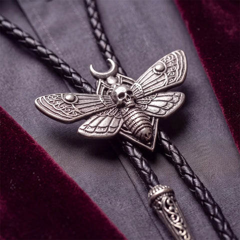 Antique Silver Winged Skull Bolo Tie with moth pendant and braided leather cord