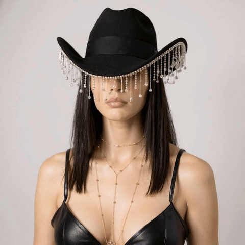 Black rhinestone tassel cowboy hat worn by a woman, featuring fringe and a stylish curved brim.