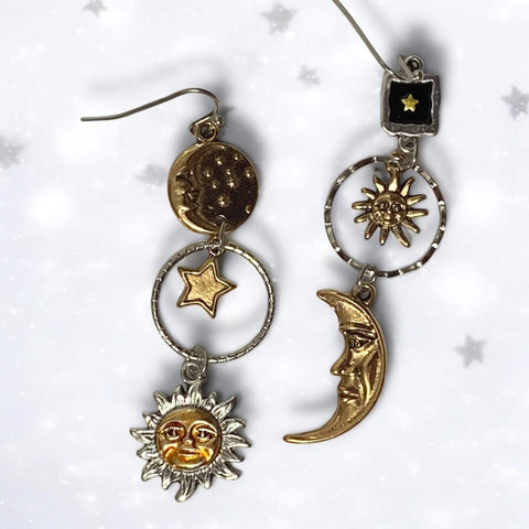 Cosmic sun moon star dangle earrings in silver and gold. Asymmetrical celestial charms with boho Y2K, witchy, gothic fashion influence. Lightweight drop earrings.