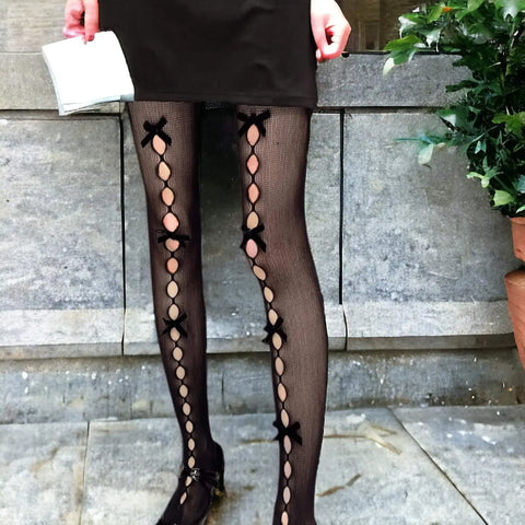 Cut out ribbon fishnet tights with small diamond mesh, bow accents and statement front leg detail black