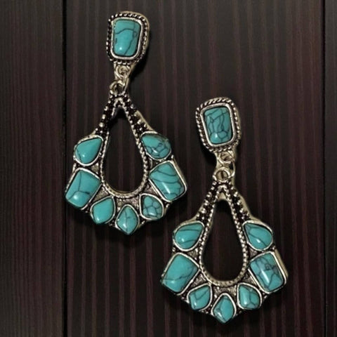 close-up of braided silver frame with faux turquoise stone wood background