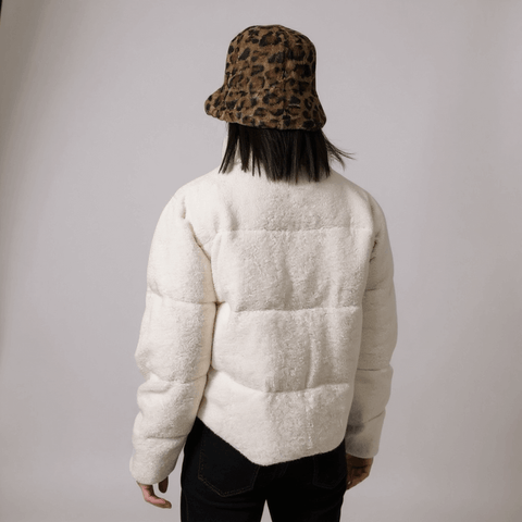 woman wearing back view of cropped sherpa quilted white puffer showing bomber silhouette