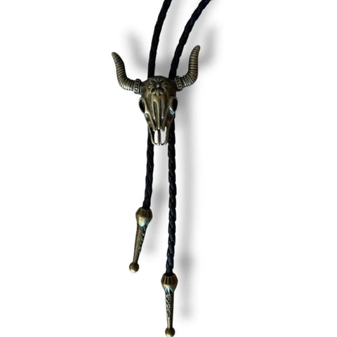 Antique gold steer skull bolo tie with adjustable slide and braided faux-leather rope. Unisex Western neckwear for concerts, festivals, and everyday edge.