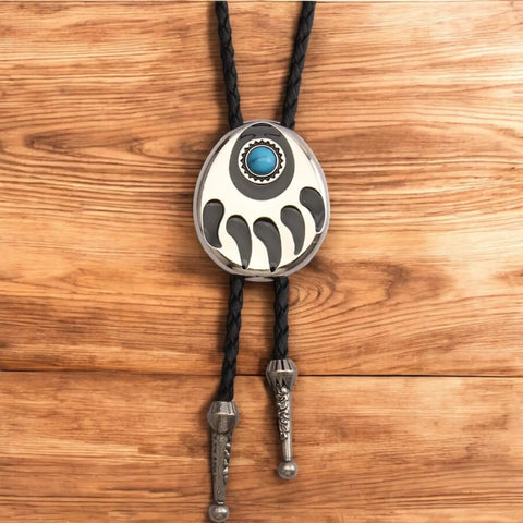 Two bear paw bolo ties with black braided leather cords: silver-tone faux turquoise bear claw slider and black stone bear paw pendant with antique metal tips.