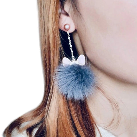 Woman wearing Cat Ear Fur Ball Dangle Earrings with mink pom poms, enamel ears, and gold chain drops