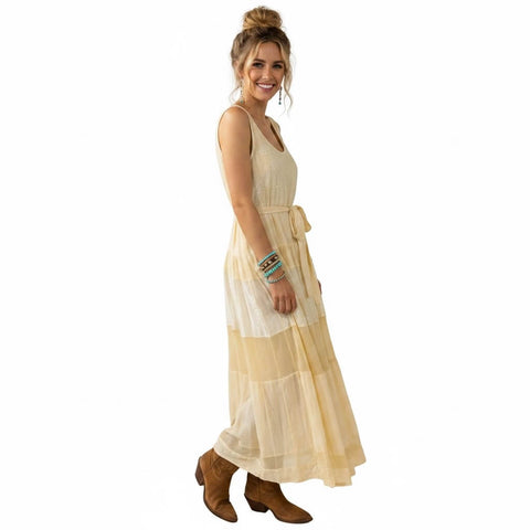 woman wearing Free People cream sleeveless tiered panel maxi dress with scoop neckline and waist tie
