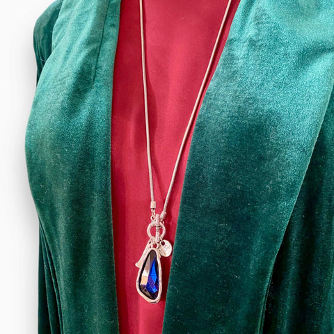 Silver talisman crystal pendant necklace with bold blue-purple faceted stone on silver toggle snake chain, mystical and adjustable statement jewelry piece.