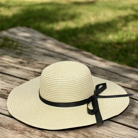 Floppy wide brim straw sun hat with black ribbon band, sustainable braided straw, boho chic summer fashion.