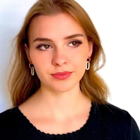 woman wearing pair of gold hoop oval link drop earrings