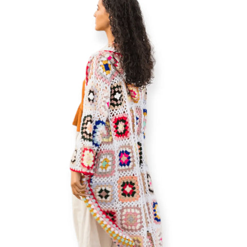 Granny square crochet long cardigan with hood displayed on a model from the side, showcasing vibrant floral motifs.