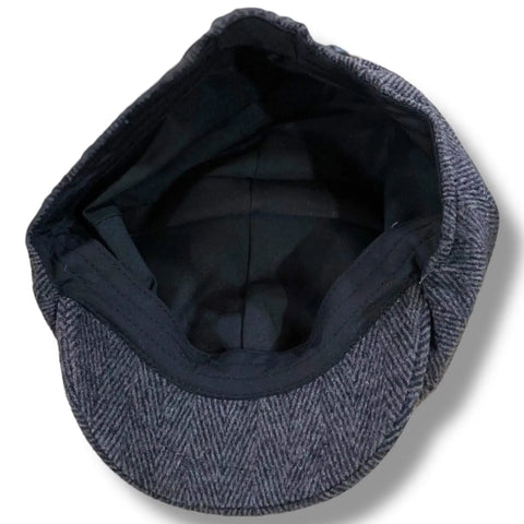 Gray tweed herringbone newsboy cap with short stiff brim and button top, styled as a vintage men’s flat cap.
