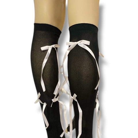 Black knee high socks with contrasting white satin bow ribbons, coquette Y2K streetwear fashion.
