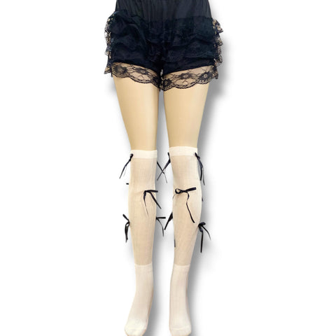 White knee high socks with bold black satin bow ribbons, balletcore legwear for Y2K and festival fashion.

