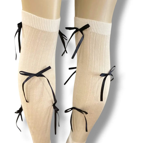 White knee high socks with bold black satin bow ribbons, balletcore legwear for Y2K and festival fashion.
