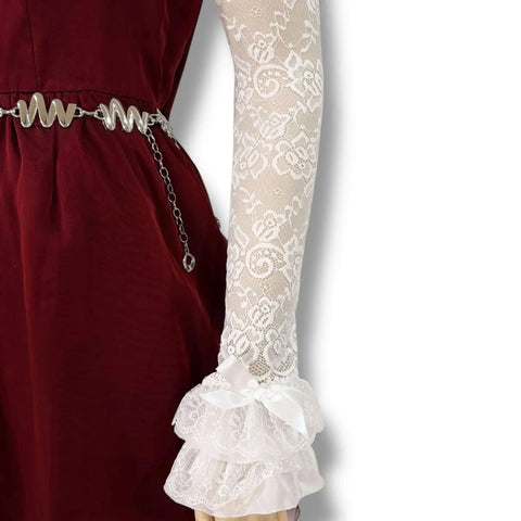 White Lace Ruffle Arm Covers Extra Long Sleeves worn with a burgundy dress featuring ruffled cuffs and a silver belt.