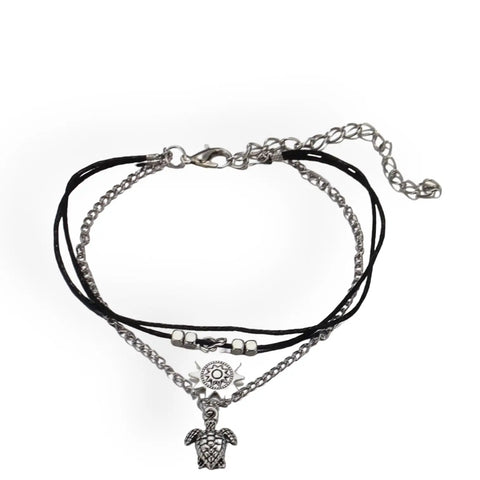 Close-up of silver turtle and sun charms on boho anklet