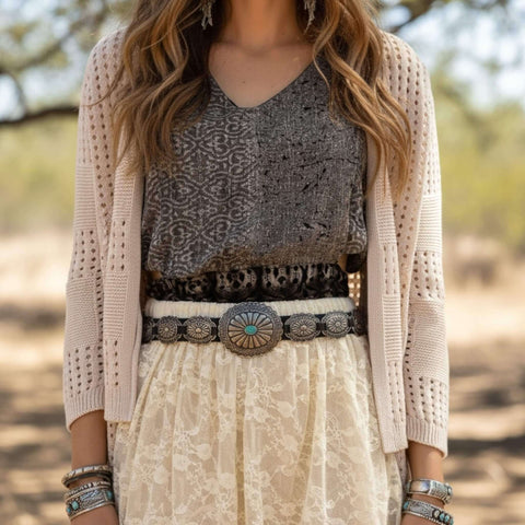 Beige Long Sleeve Crochet Cardigan Sweater woman wearing with black brown geo top, concho belt, cream lace midi skirt