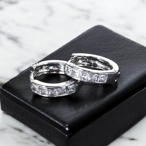 flat lay on jewelry box Silver Crystal Hinge Hoop Earrings with channel-set zirconia, huggie shape, and secure click-latch closure