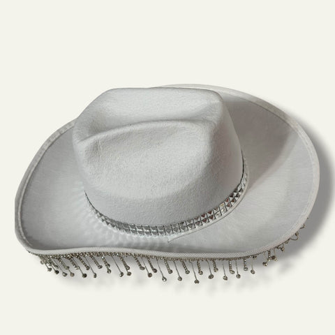 side view of Sparkling Fringe White Cowboy Hat with rhinestone tassel trim, silver studded band, wide brim, and chin strap