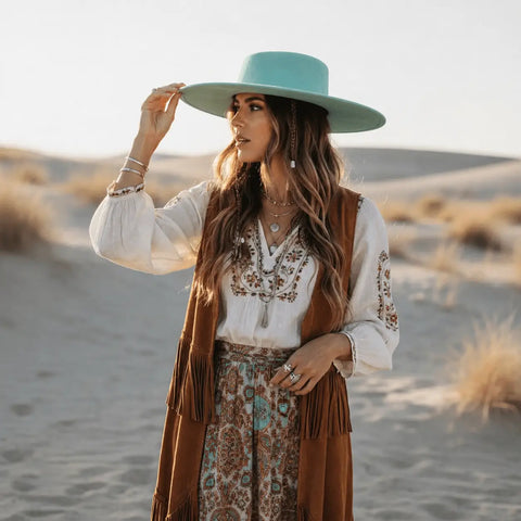 Stylish Round Crown Wide Brim Fedora worn by a woman with a turquoise hat in a desert setting.
