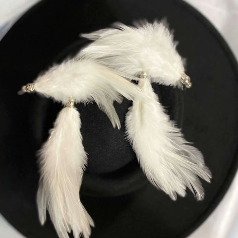 image of White Feather fish hook earrings flat lay on black boater hat 