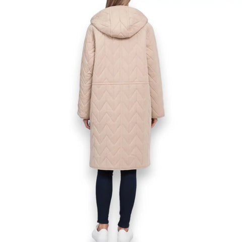 woman wearing back view of chevron quilting on mid-length tan anorak coat on white background