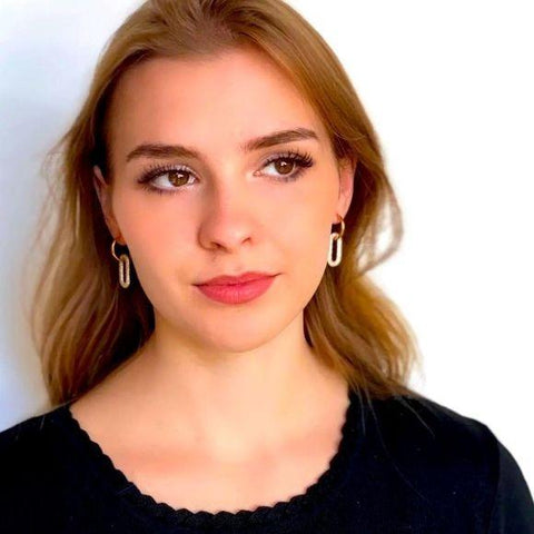 woman wearing pair of gold hoop oval link drop earrings